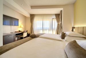 a hotel room with a large bed and a desk at Hotel Marina in Krk +94 photos