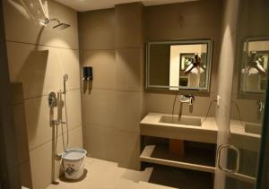 a bathroom with a shower and a sink and a mirror at Hotel Abhilasha Premium in Dewās