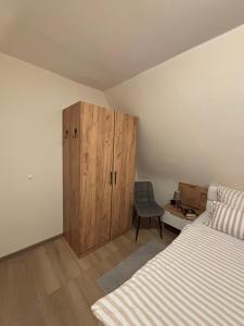 a bedroom with a wooden cabinet next to a bed at fewo-brigitte in Buxtehude +20 photos