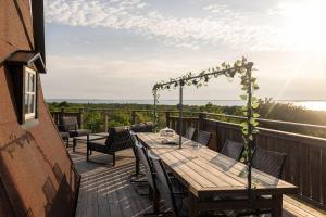 a wooden deck with a table and chairs on a balcony at Windmill with the best sunset view in Borgholm