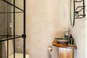 a bathroom with a sink and a glass shower at Windmill with the best sunset view in Borgholm
