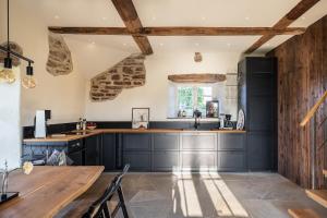 a kitchen with black cabinets and a wooden table at Windmill with the best sunset view in Borgholm