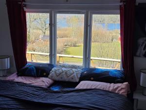 a bed in front of a window with a view at Anten Lake House in Alingsås
