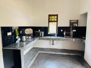 a kitchen with a marble counter top and a window at Rilu Surf Stay Arugambay in Arugam Bay +109 photos