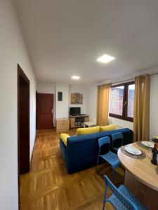 a living room with a blue couch and a table at Plavi apartman Airport in Belgrade