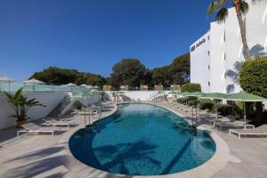 a swimming pool with lounge chairs and umbrellas at a hotel at HM Isabela-Adults Only in Santa Ponsa