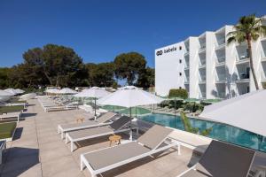 a pool with lounge chairs and umbrellas in front of a hotel at HM Isabela-Adults Only in Santa Ponsa