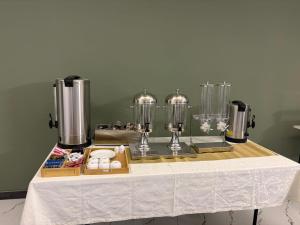 a table with a white table cloth and some blenders at Nana Grand Hotel Yerevan in Yerevan