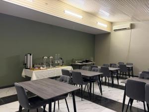 a dining room with tables and chairs and a wall at Nana Grand Hotel Yerevan in Yerevan