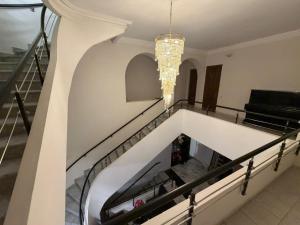 a staircase in a building with a chandelier at Nana Grand Hotel Yerevan in Yerevan