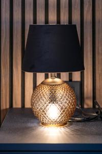 a lamp sitting on a table with a black lamp shade at Arena Lux Apartments in Zagreb