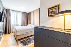 a hotel room with a bed and a dresser in it at Arena Lux Apartments in Zagreb