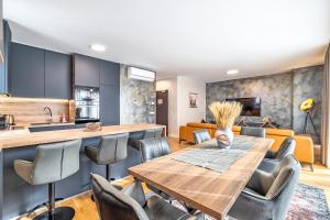 a kitchen and dining room with a wooden table and chairs at Arena Lux Apartments in Zagreb