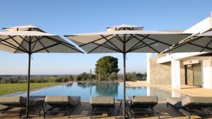 a patio with chairs and umbrellas next to a pool at Sani Chateau in Sani Beach +11 photos