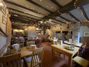 a dining room with wooden tables and chairs at The Stables Inn in Minsterley
