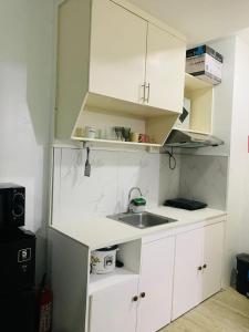 a kitchen with white cabinets and a sink at Calm & Cozy Hideaway in Tunkong Manga +6 photos