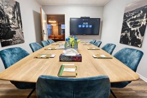 a conference room with a large wooden table and blue chairs at ADAPT APARTMENT HOTEL Siegen in Siegen