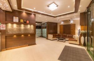 a lobby with a waiting room with couches and a table at Hotel Sawood International in Kolkata