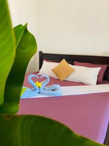 a bed with two swans towels on it at Rilu Surf Stay Arugambay in Arugam Bay