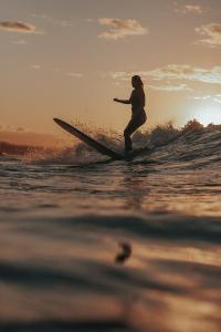 a person riding a wave on a surfboard in the ocean at Rilu Surf Stay Arugambay in Arugam Bay