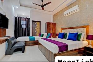a hotel room with two beds and a television at The MoonLight Hotel in Zirakpur