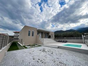 a house with a swimming pool and mountains in the background at MARRONI RETREAT - Pool - Spa - Gym in Skotina