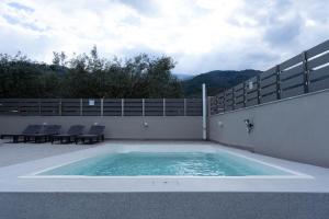 a swimming pool on the side of a house at MARRONI RETREAT - Pool - Spa - Gym in Skotina