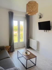 a living room with a couch and a coffee table at Appartement en Corrèze in Le Lonzac