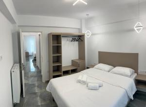 a bedroom with a large white bed with towels on it at MARRONI RETREAT - Pool - Spa - Gym in Skotina +38 photos