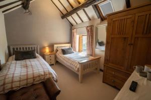 a bedroom with two beds and a mirror at The Stables Inn in Minsterley