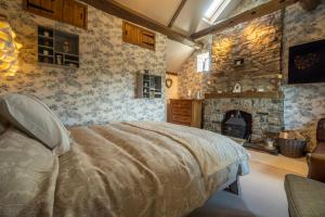 a bedroom with a bed and a stone fireplace at The Stables Inn in Minsterley