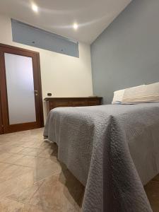 a bedroom with a bed with a blanket on it at Appartamento Accogliente tra Borghi e Natura in Castelluccio dei Sauri