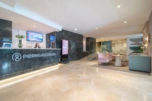 a lobby of a dermatologists office with a table and chairs at Hotel Costa Málaga - Adults Recommended - by Pierre & Vacances in Torremolinos