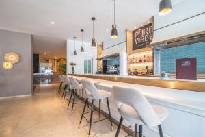 a bar with a row of white stools at Hotel Costa Málaga - Adults Recommended - by Pierre & Vacances in Torremolinos +43 photos