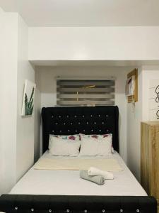 a bed with a black headboard in a room at Calm & Cozy Hideaway in Tunkong Manga