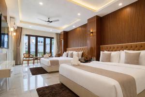 a hotel room with two beds and a table at Valmere Chery Blossom Suites in Shillong
