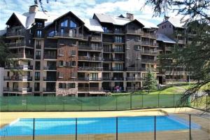 a large building with a tennis court in front of it at Risoul 1850 studio Résidence LesFlorins2 pour 4 pers avec accès direct sur les pistes in Risoul
