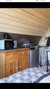 a kitchen with a microwave and a stove at L écureuil in Granges-Aumontzey