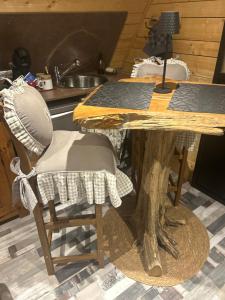 a kitchen with a table and two chairs and a table with at L écureuil in Granges-Aumontzey