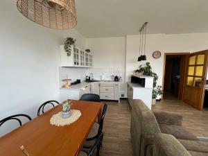 a kitchen and living room with a wooden table and a kitchen and a dining room at Apartamenty Vega in Charzykowy