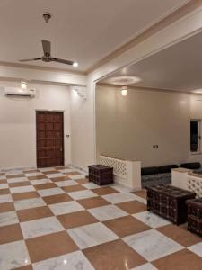 an empty room with a checkered floor and a ceiling at Tej Gadh Jambuda in Sālūmbar +3 photos