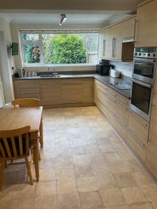 a large kitchen with a table and a window at Cheshire 1 bedroom apartment - minimum 3 night stay please - garden view in Cheadle Hulme