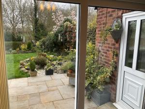 a door leading to a garden with potted plants at Cheshire 1 bedroom apartment - minimum 3 night stay please - garden view in Cheadle Hulme