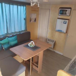 a small living room with a table and a couch at GoldenSand mobilehome in Lido di Dante +12 photos