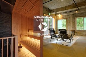 a room with two black chairs and a table at 三笠館Mikasakan 本館 in Kinokawa