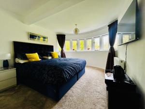 a bedroom with a blue bed and yellow pillows at Hadrian House in East Preston