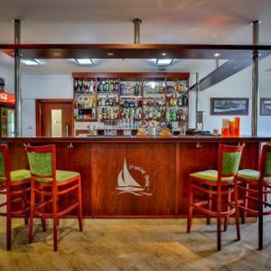 a bar with red chairs and a counter in a restaurant at Marina Orlík in Kowářow