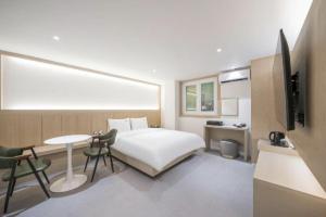 a bedroom with a bed and a desk and a tv at 드므호텔 in Changwon