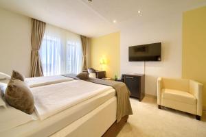 a bedroom with a bed and a tv and a chair at Hotel Marina in Krk