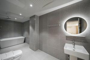 a bathroom with a toilet and a sink and a mirror at 드므호텔 in Changwon +23 photos